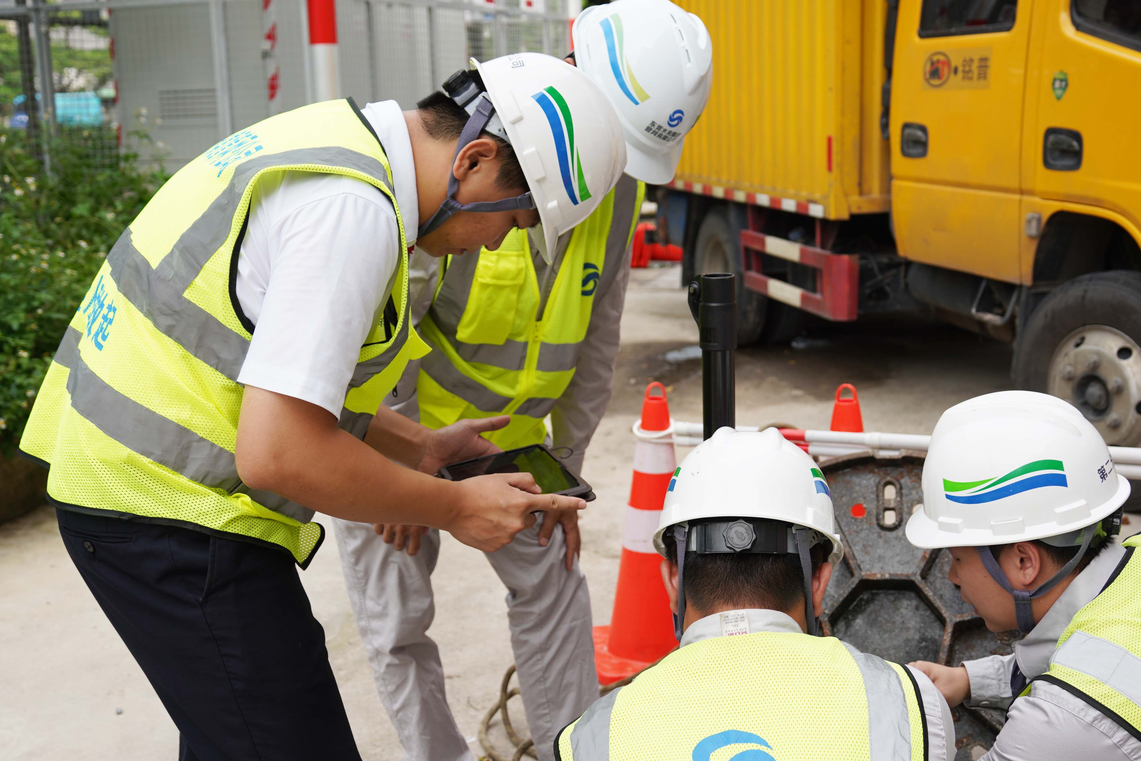 卢伟佳（左一）日常检测排水管网.JPG